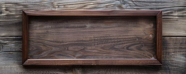 A modern wooden picture frame with a dark walnut finish, set against a light, textured wooden background. The sleek design of the frame contrasts with the rustic texture of the wood.