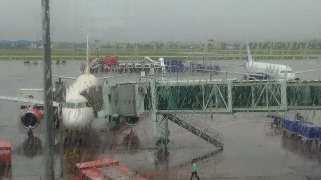 Kolkata, West Bengal, India - 12.09.2022 : Netaji Subhas Chandra Bose airport, Kolkata airport. Shot through wet glass, monsoon rainy abstract busy view of airport. Flight arrival and departure area.