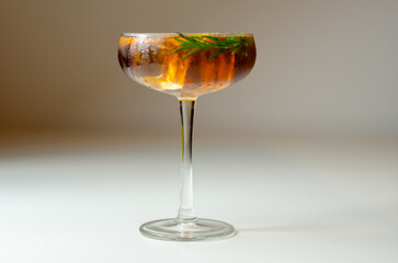 A glass of cocktail with a garnish of rosemary on top