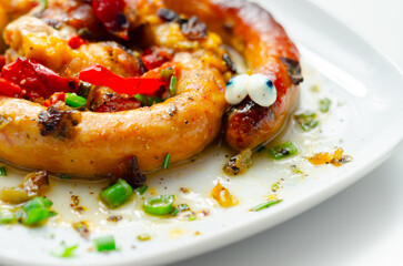 A plate of food with a sausage that has eyes on it
