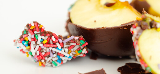 A chocolate covered apple with sprinkles on top