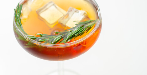 A glass of cocktail with a garnish of rosemary on top