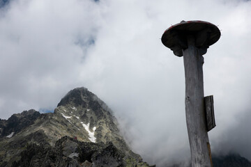 An information board on the Lomnica saddle showing the direction for tourists in the High Tatras