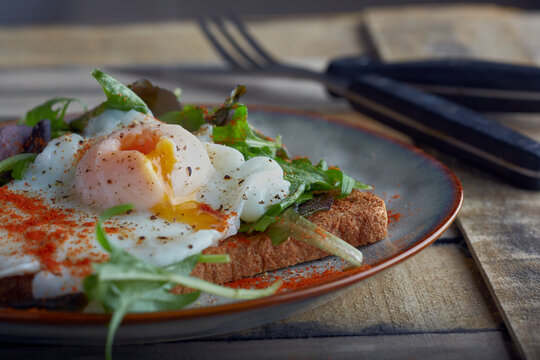Poached egg on toast garnished with seasoning.