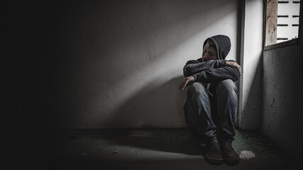 Asian man addict drug in the deserted place,A junkie feels alone in this world,Sad young man sitting in the corner of the room,People are stressed and have depression