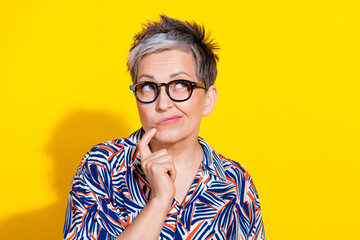 Portrait of nice aged woman look empty space wear shirt isolated on yellow color background