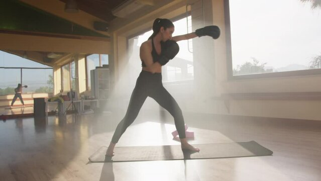 Sunlight Hitting A Woman Training With Boxe Gloves 