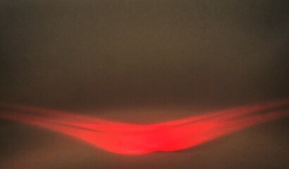 Abstraktes Motiv mit brauner Metallwand und orangeroter Welle mit Licht als Hintergrund