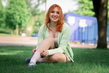 Portrait of a young beautiful red-haired girl in an urban environment.