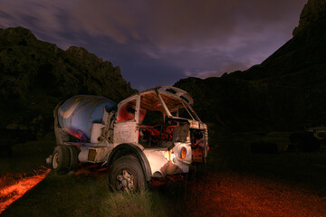 Fototapeta premium Old trucks in a dilapidated state artificially illuminated at night, in the Atxarte quarry, Bizkaia