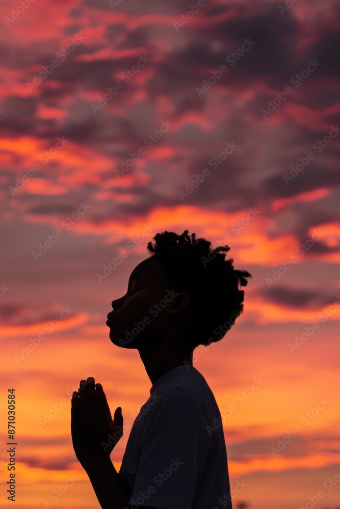 Poster a person stands in front of a beautiful sunset with warm colors and clouds