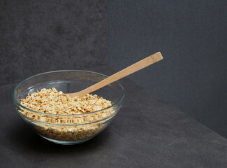 Dried soy bean meat mince in a glass bowl with a wooden spoon, grey kitchen table