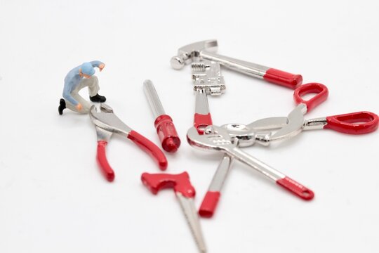 miniature figurine of a repairman with different toy tools