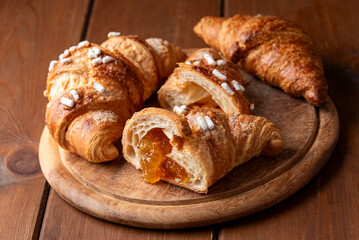 Deliziosi croissant freschi ripieni di marmellata di albicocche, colazione europea 