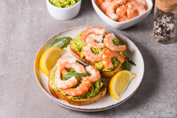 Shrimps on toast or sandwich with avocado and lemon. Breakfast concept. Bruschetta. 