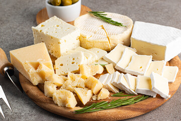 Wooden board with various cheese and olives. Brie. Camembert. Parmesan, feta, blue cheese. Italian,...