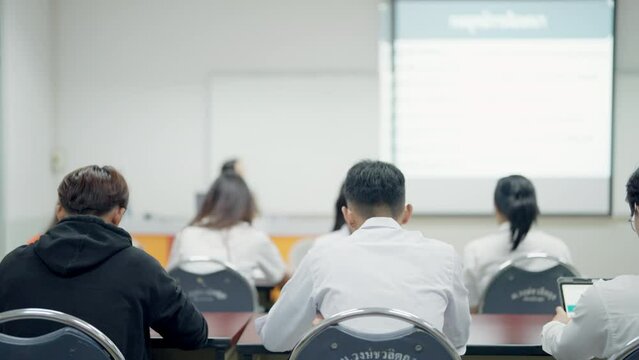 A classroom with a teacher and students sitting at desks. Scene is educational and focused