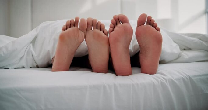 Relax, feet or couple in bed for love, intimacy or sleep in on weekend at home. Marriage, people or cuddle in bedroom for relationship, romance or rest with partner for trust, commitment or comfort