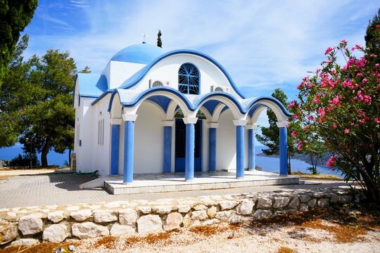 Beautiful view of Agia Kyriaki church with its blue roof and white walls on a hill with sea view in Tolo in Greece