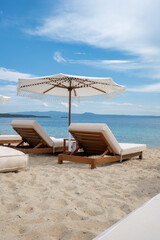 pair of luxurious sunbeds and umbrella on a beautiful beach