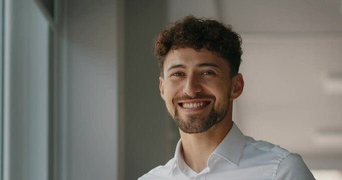 Dreaming caucasian handsome young man agent worker deep in thoughts look away turn head at camera happy male human face friendly businessman, guy smiling with toothy smile.