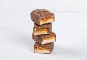Candy bar with nougat, caramel, peanuts and hazelnuts. In chocolate. Close-up