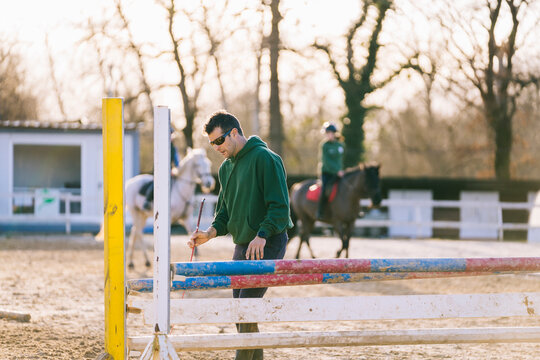 Horseback riding coach preparing obstacles