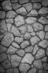 Empty monochrome black and white (dark gray) embossed stone wall for abstract background and texture for interior or exterior design. Beautiful patterns, space for work, banner,Vertical.
