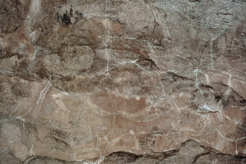 Empty cracked light brown natural stone wall on cave for abstract background and texture. beautiful patterns, space for work, banner, seamless wallpaper close up.