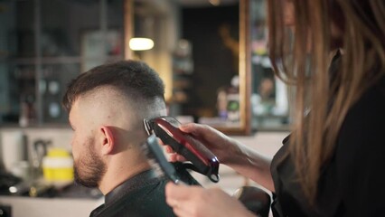 Young female barber making men's undercut haircut hairstyle using Haircut Clipper in Modern style barber shop. Haircare service local small business, cosmetics and personal care industry 4K video