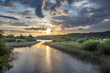 Naklejka premium A calm river with a sunset in the background