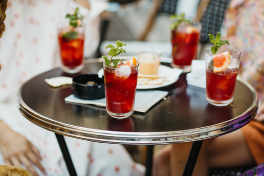 close up of red mint cocktails on a round bistro table