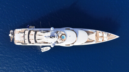 Aerial drone top down photo of luxury yacht with wooden deck anchored in deep blue Aegean sea,...