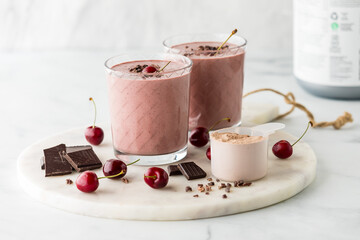 Cherry chocolate protein smoothie topped with fresh cherries and cacao nibs.