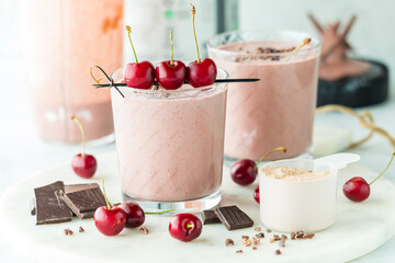 Cherry and chocolate protein smoothie, garnished with fresh cherries.
