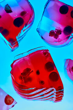Futuristic transparent red jelly slices over blue light background.