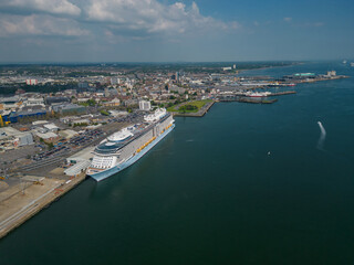 Fototapeta premium Large cruise ship moored at Southampton UK. Panoramic view of the Southampton city and the docks towards open sea waters. High altitude aerial on a sunny day.