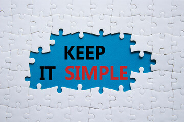Keep it Simple symbol. Concept words Keep it Simple on white puzzle. Beautiful blue background....