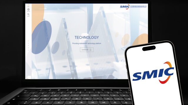 SMIC logo on a smartphone screen with website in background. SMIC, Semiconductor Manufacturing International Corporation, is China's largest semiconductor foundry.
