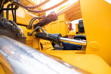 Worker man check pipe system of hydraulic hose valves in industry machinery.