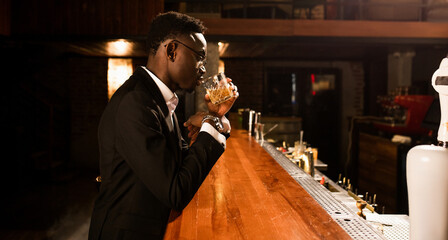 A successful man in expensive and luxurious clothes drinking alcohol 