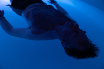 Man peacefully floating in sensory deprivation