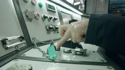 The train driver presses the button. Metro train control panel.