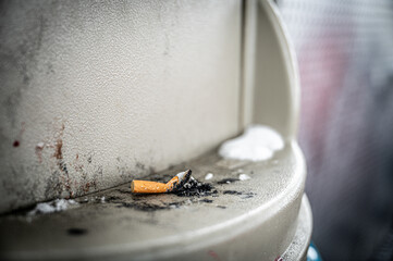 extinguished cigarette on a trash can