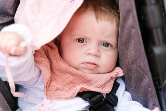 Charming little child in sweater lying on pushchair