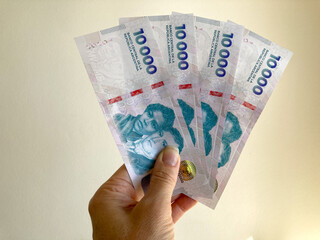 hand holds new 10.000 Argentine peso bills of Central Bank of the Argentine Republic