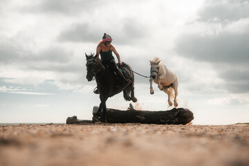 Horse riding and jumping on a beach, woman riding a horse