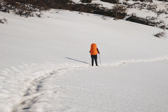Hiker crossing snow patch 