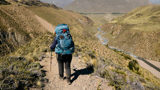 Woman hiking down a valley