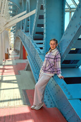 young girl posing on a metal bridge